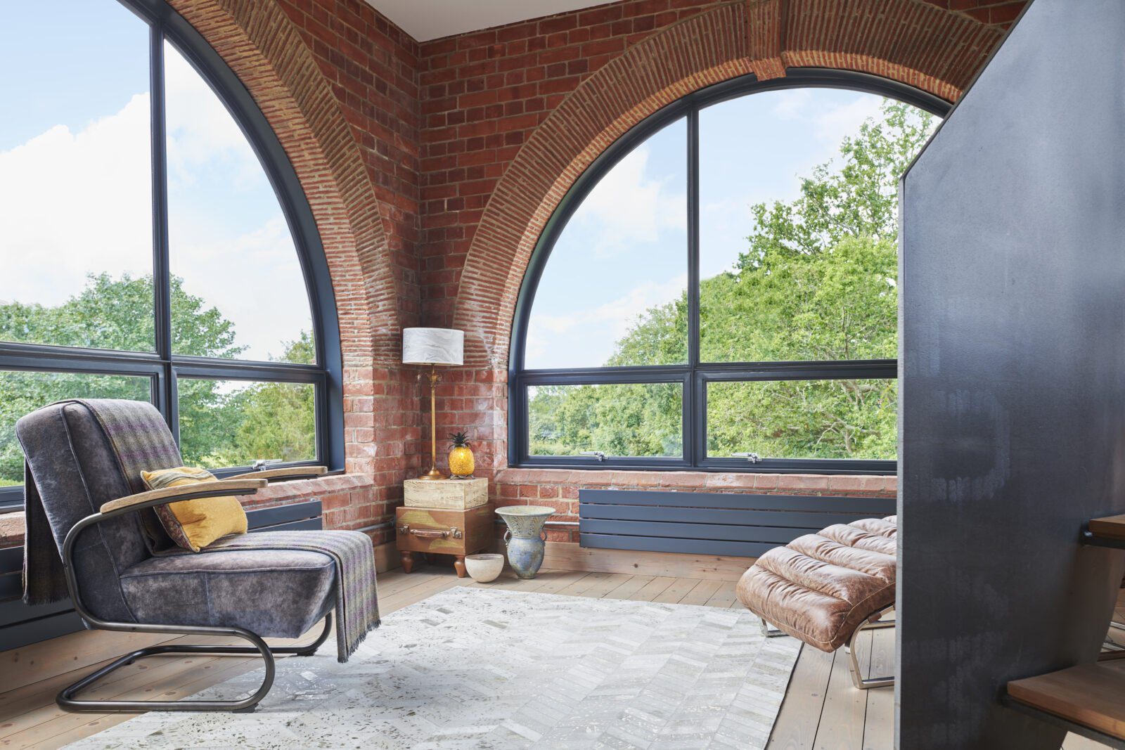 Two large semi-circular metal windows bring the outside in